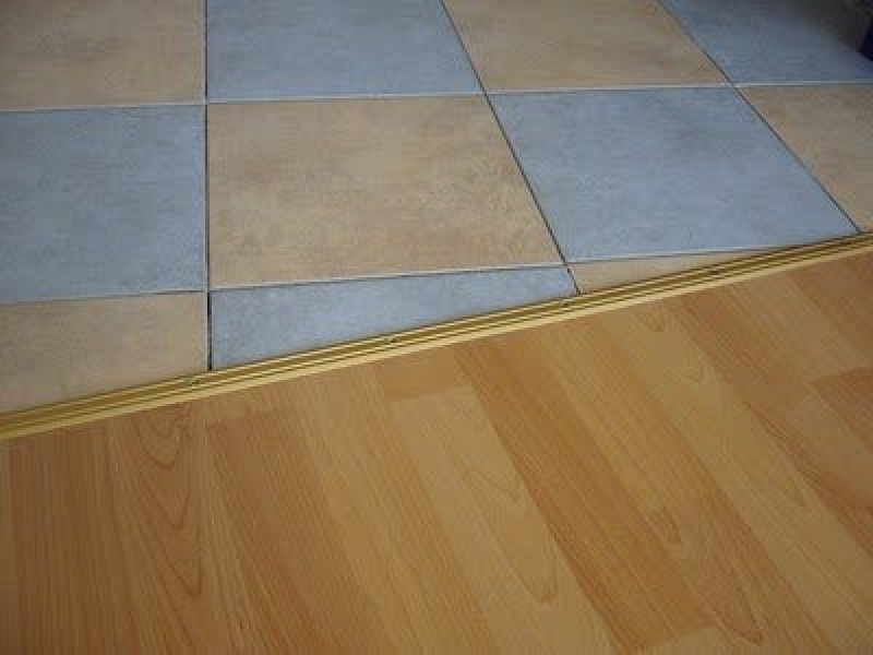 Плитка и ламинат в один уровень. Порожек для ламината и плитки. Стык ламината и плитки. Порожки плитка ламинат в интерьере. Плитка и ламинат в один уровень.